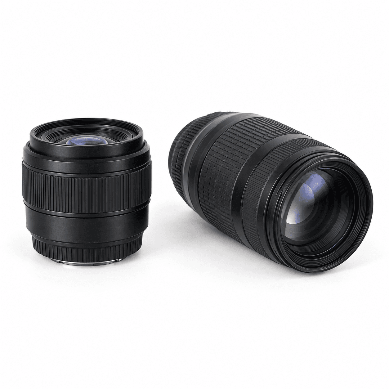 A black prime lens and a longer zoom lens on a white surface